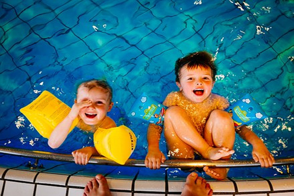 two children enjoy swimming