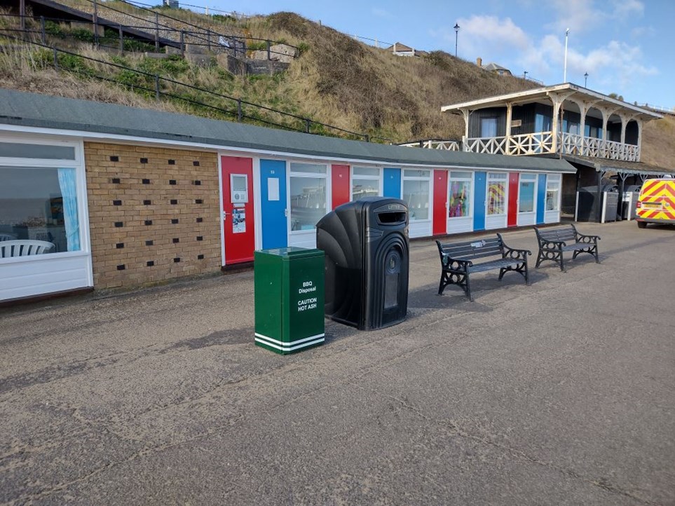 Green BBQ disposal bin outside chalets in Cromer