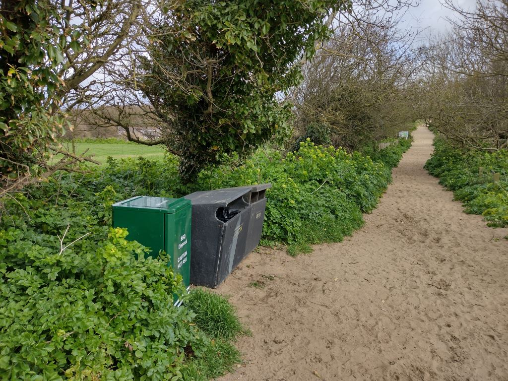 Green BBQ disposal bin outside chalets in Cromer